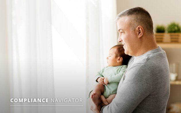 Man holding a baby while they look out a window