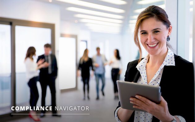 Woman in business clothing holding a tablet smiling at the camera