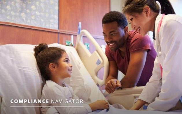 Doctor talking to young child in a hospital bed. The child's father is standing next to them