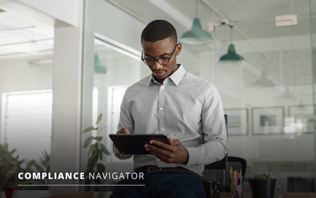 Man in business attire looking at a table while at a desk