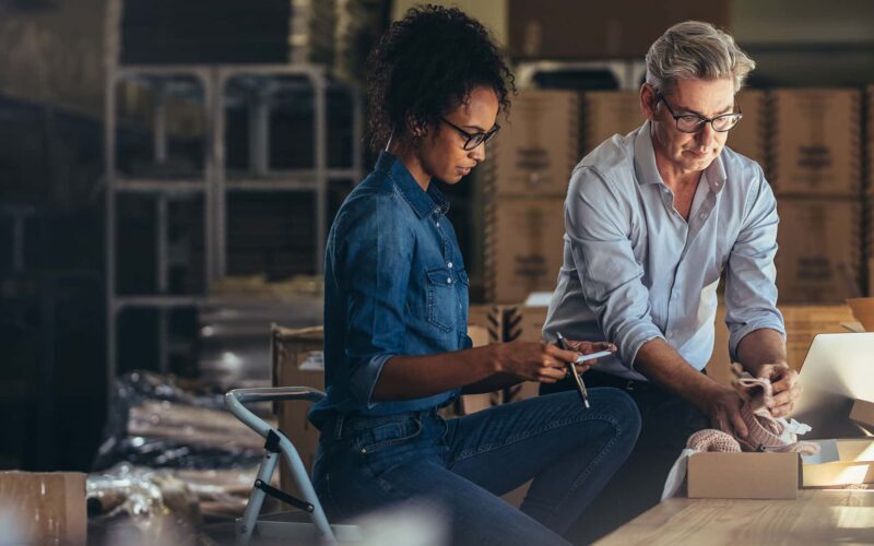 business owners working in warehouse on compliance