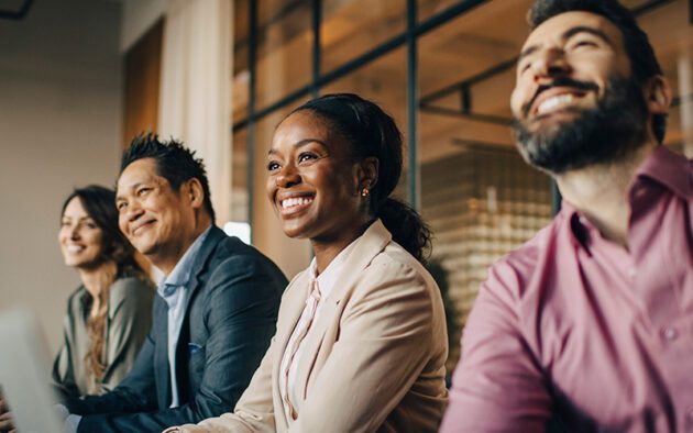 Group of people sitting at a conference table smiling