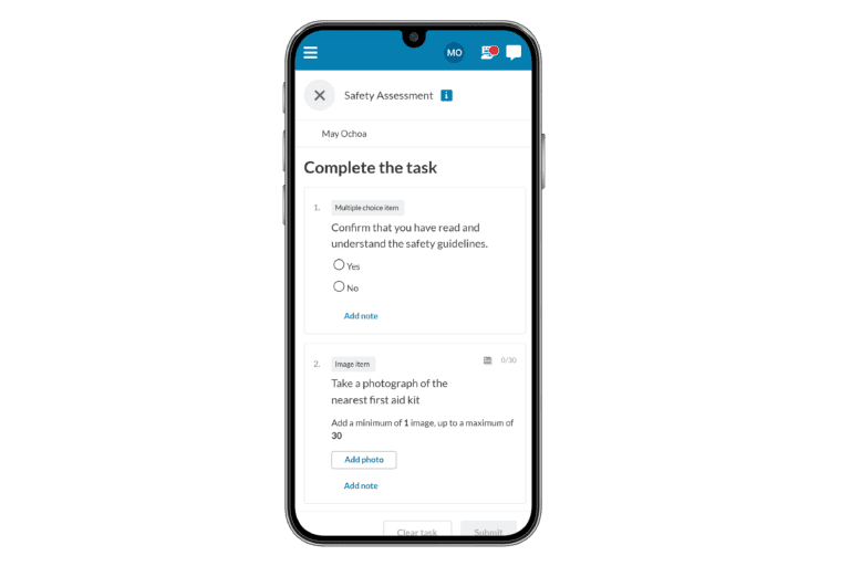 Mobile screen showing a safety assessment task with options. Tasks include acknowledging safety guidelines and photographing a nearby first aid kit.
